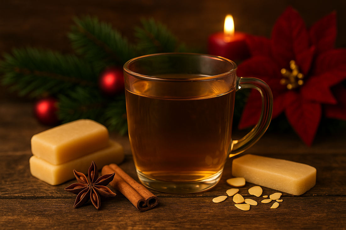 Stimmungsvolles Weihnachtsmotiv mit Glas voller goldenem Weihnachtsstollen Bio-Tee, umgeben von Marzipan, Zimtstangen, Sternanis, Mandelblättchen, Tannenzweigen, roter Kerze und Weihnachtssternblüte – warme Adventsatmosphäre.